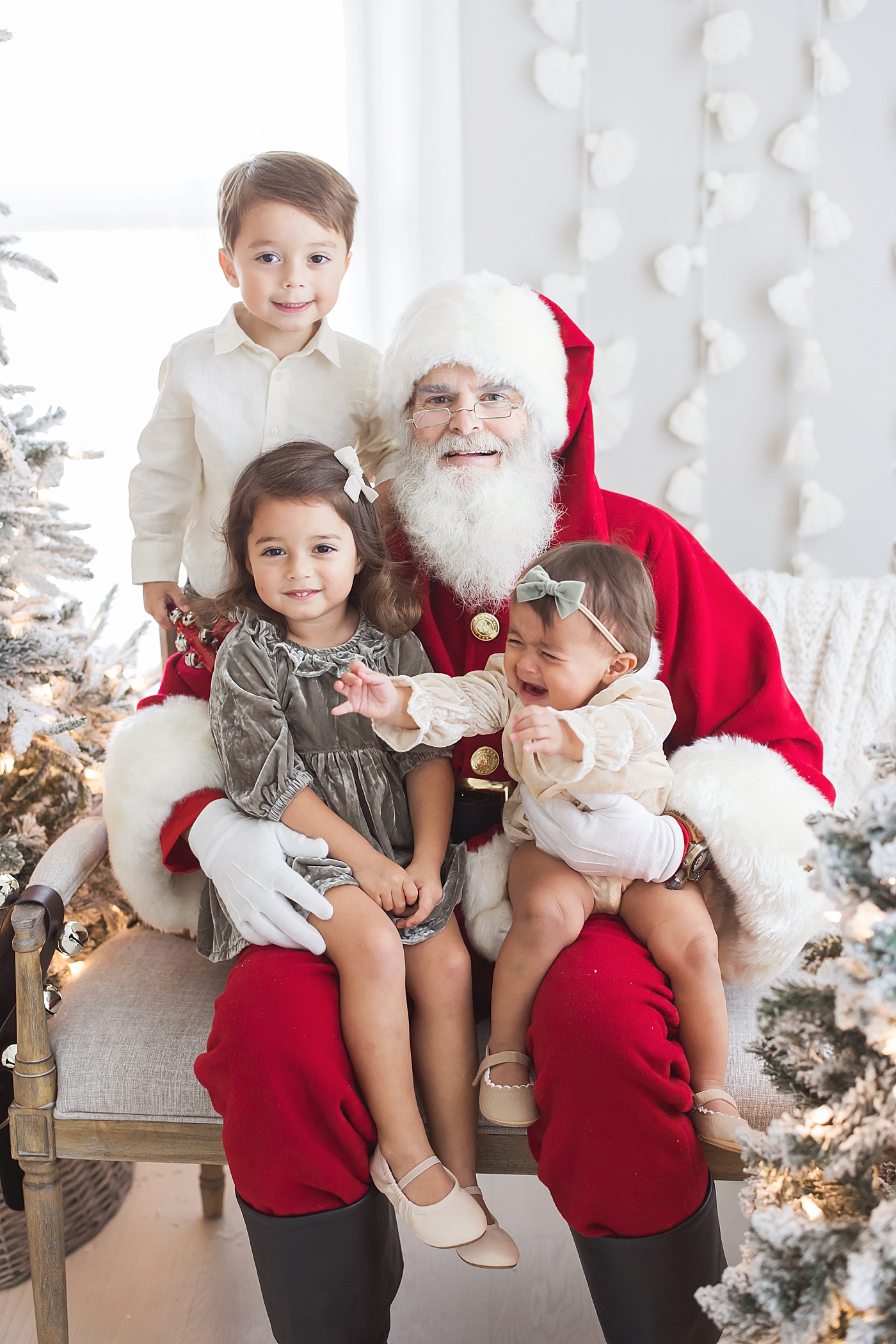 Siblings sitting on Santa's lap. Photo by Fresh Light Photography.