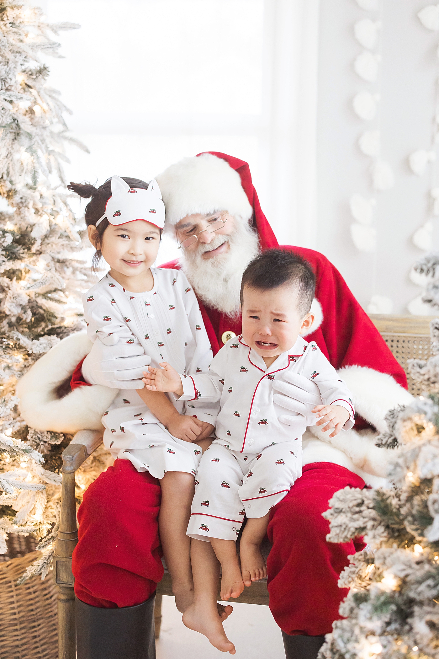 Brother and sister on Santa's lap. One is crying. Photo by Fresh Light Photography.