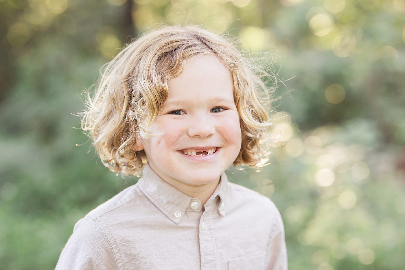 Young boy smiling with missing two front teeth! Photo by Fresh Light Photography