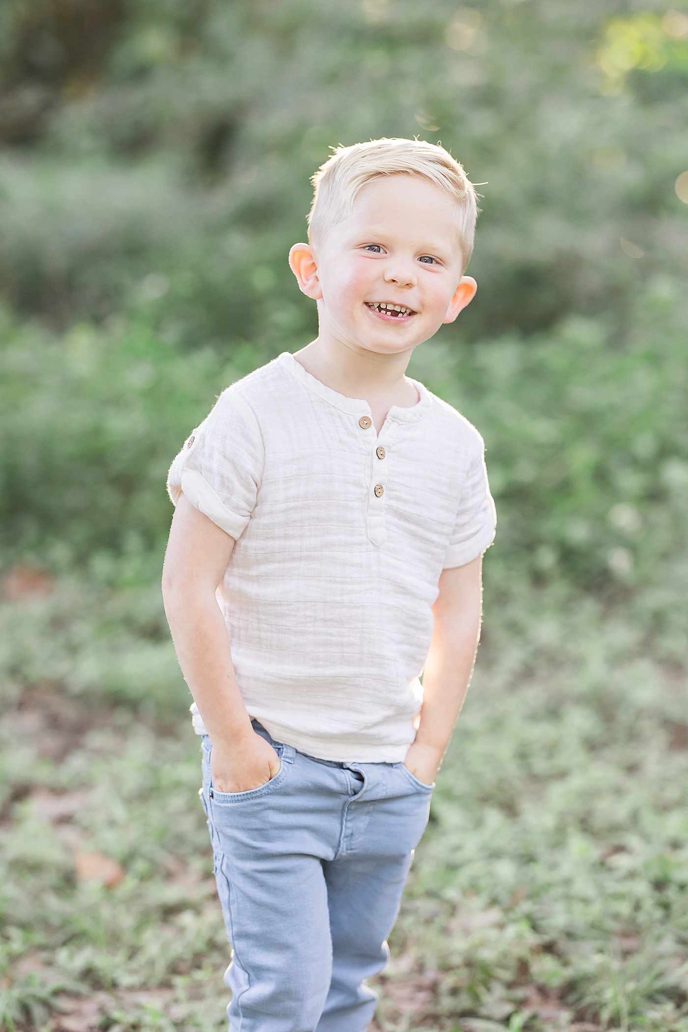 Toddler smiling for portrait during outdoor session in Houston. Photo by Fresh Light Photography