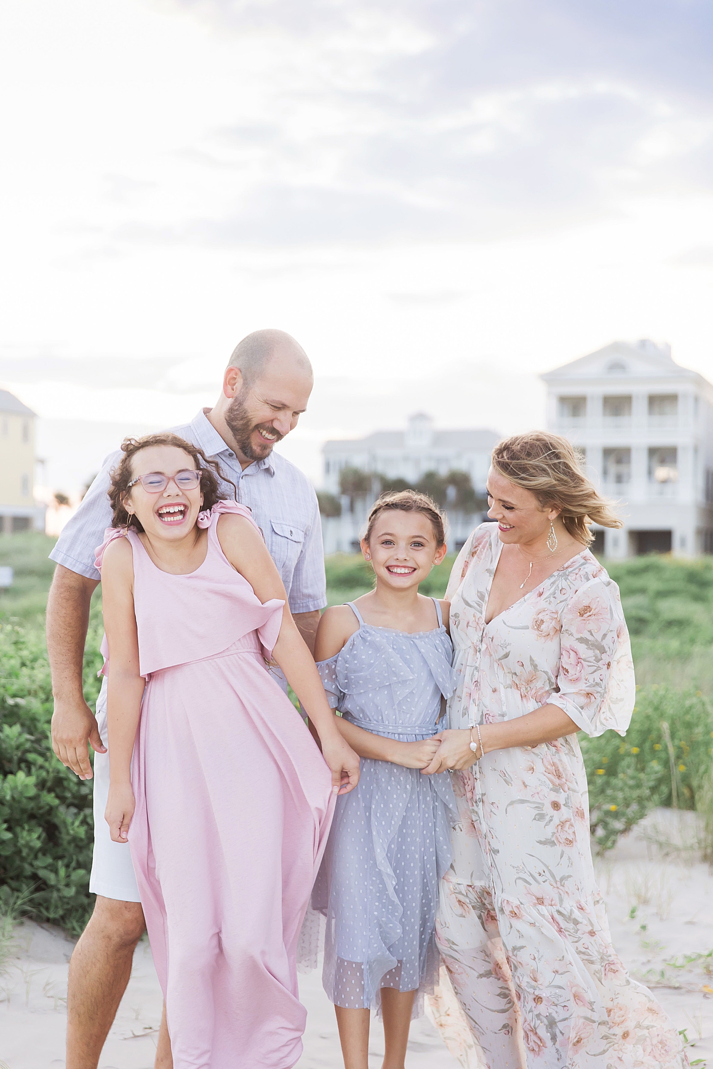 Family laughing during photos on Galveston Beach. Photo by Fresh Light Photography.