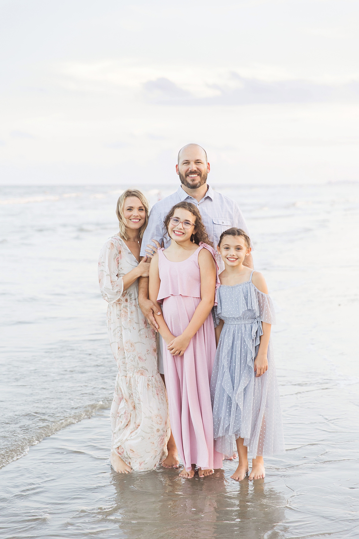 Family standing by the water during photoshoot on Galveston beach with Fresh Light Photography.
