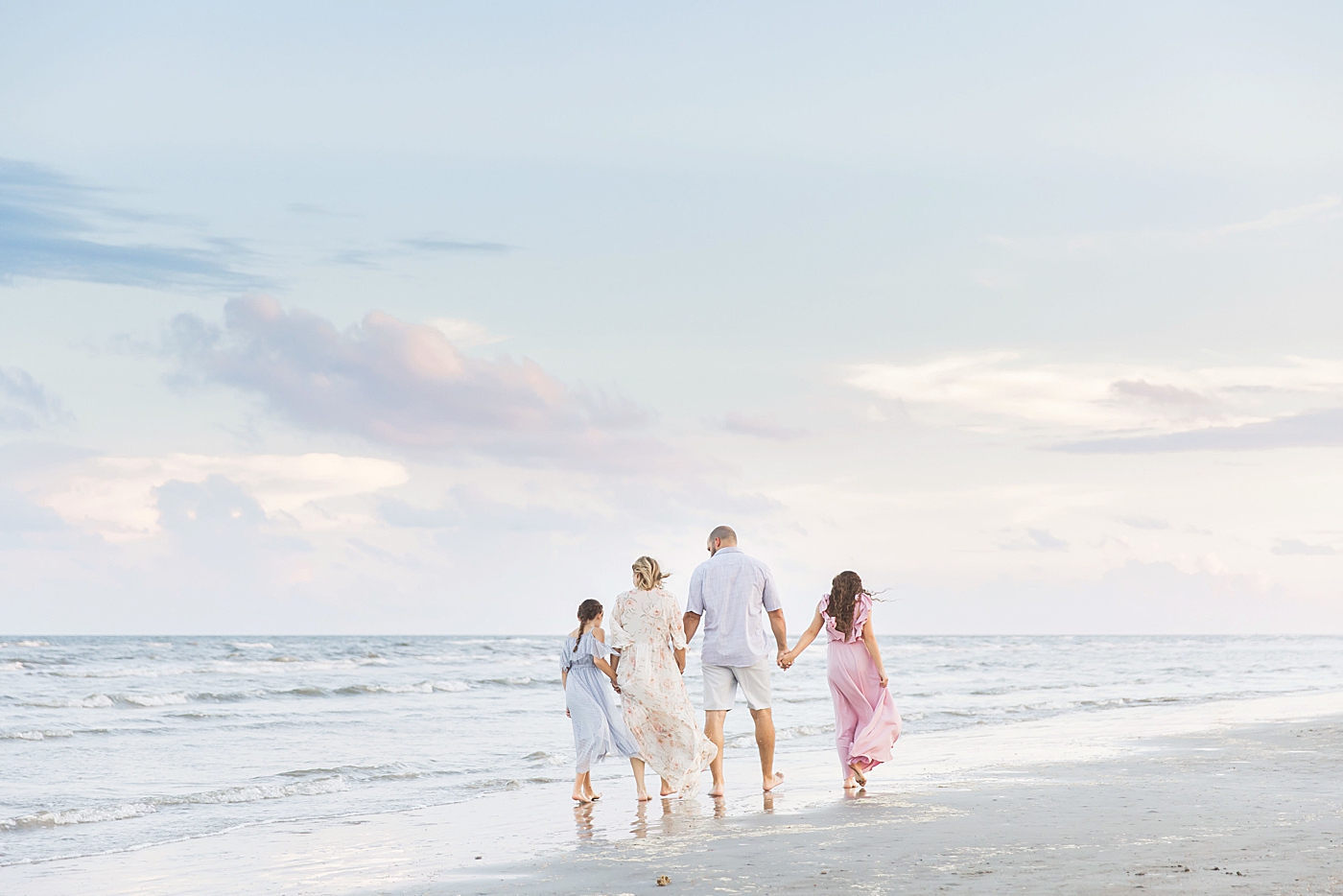 Family walking along the water on the beach. Photo by Fresh Light Photography.