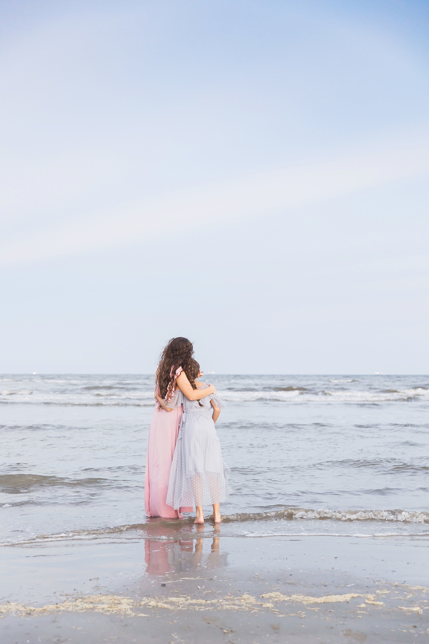 Sisters looking off into the ocean together. Photo by Fresh Light Photography.