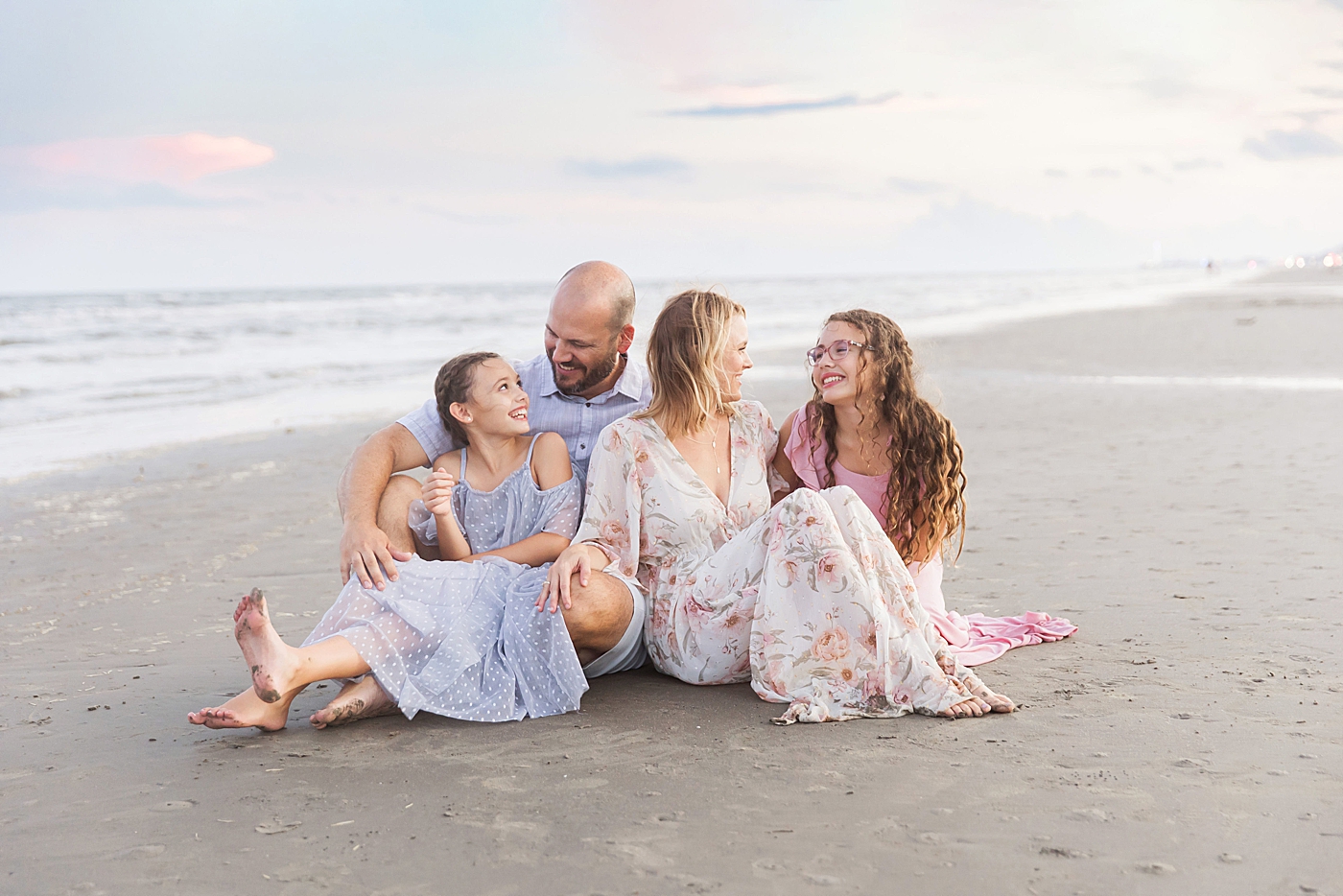 Family sitting on the beach during photoshoot with Fresh Light Photography in Galveston.