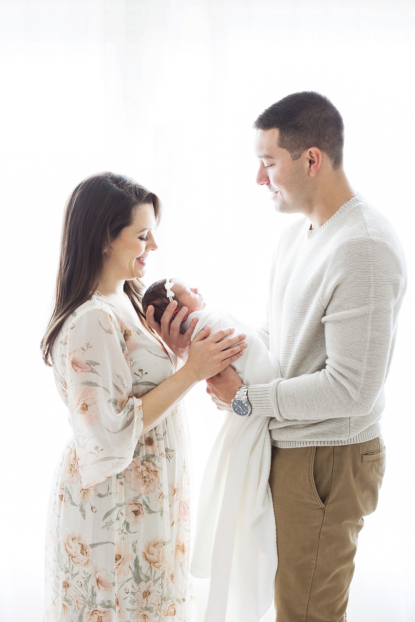 Mom and Dad looking at their daughter during studio newborn session. Photo by Fresh Light Photography.
