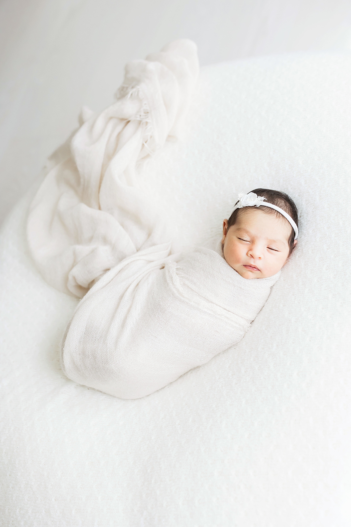 Newborn baby girl swaddled in white for photos with Fresh Light Photography.
