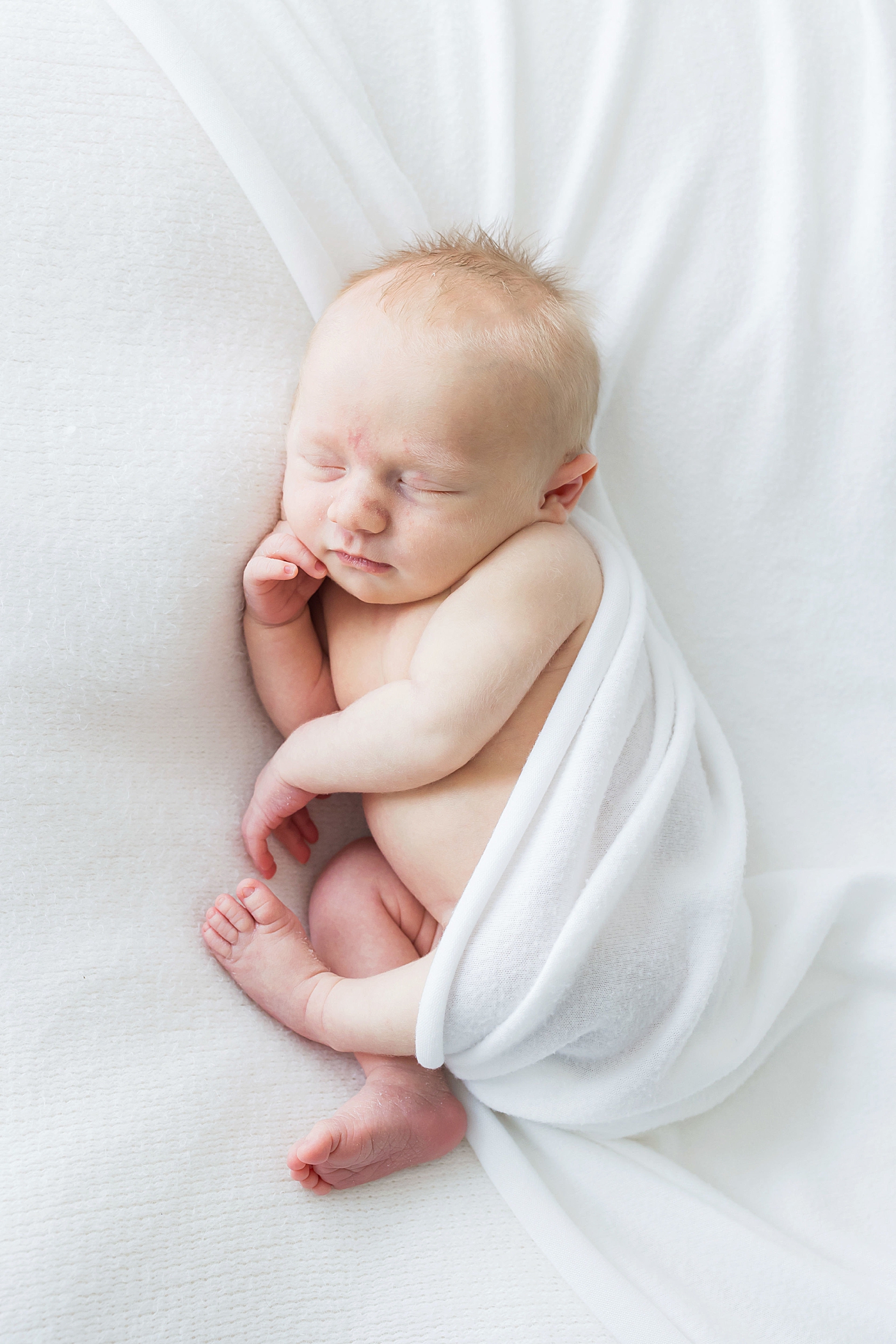 Baby boy sleeping on his side with hand up by his face. Photo by Fresh Light Photography.