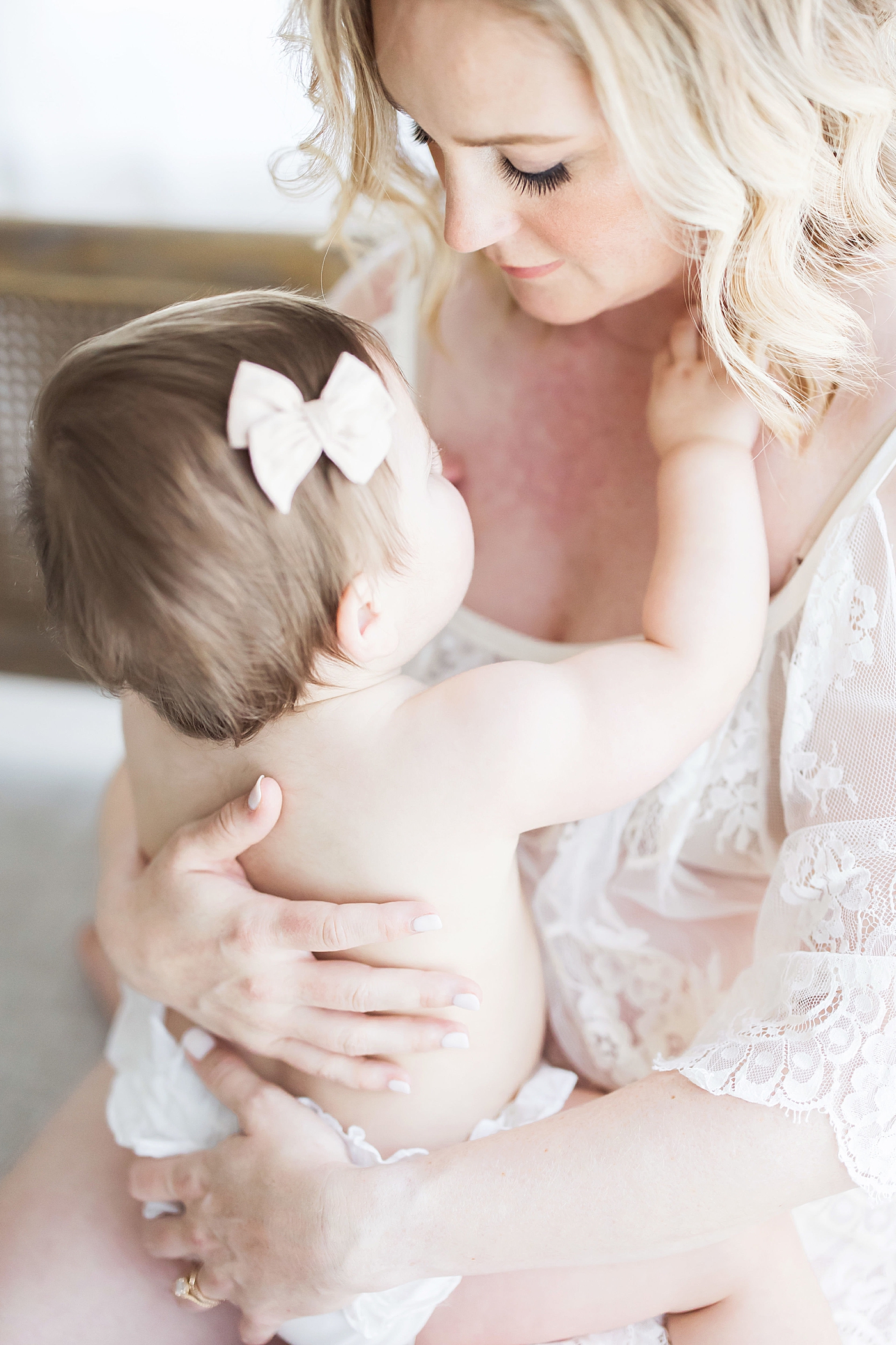 Mom holding daughter in her lap. Photo by Fresh Light Photography.
