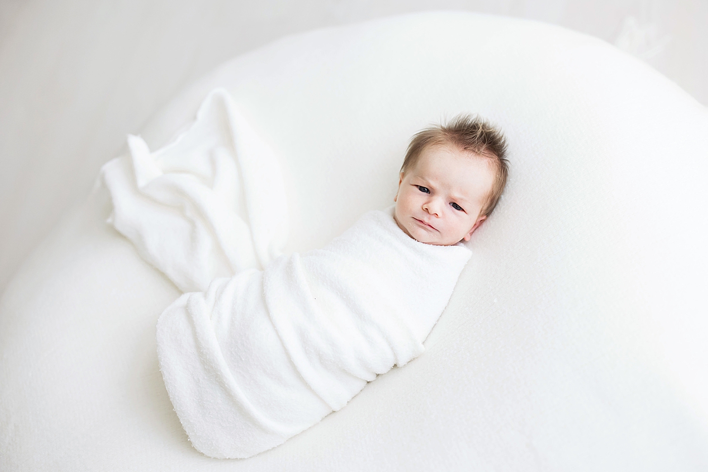Newborn baby boy wide awake and swaddled. Photo by Fresh Light Photography.