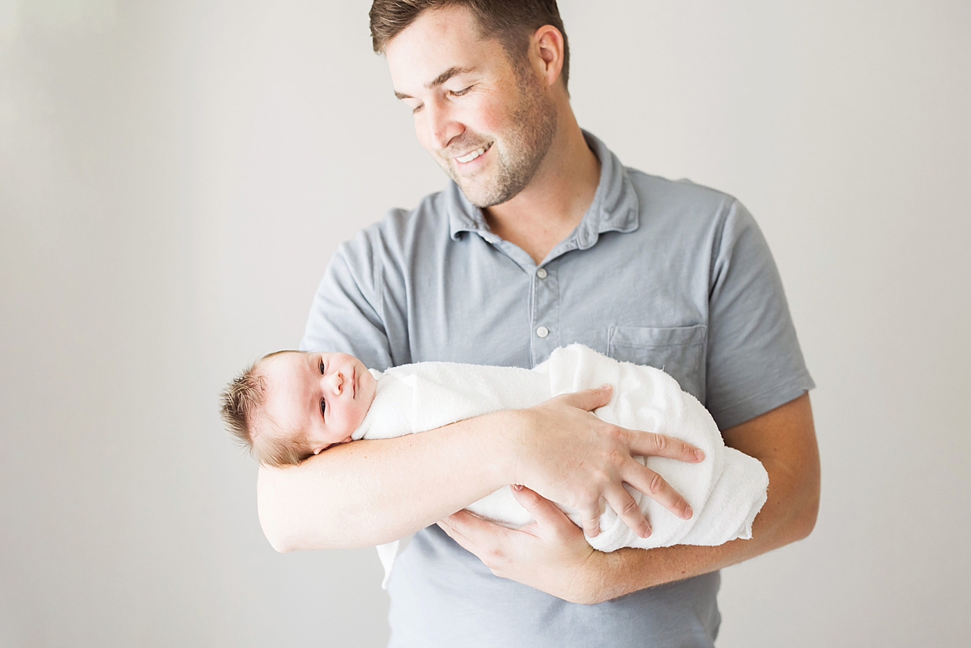 Dad holding newborn son. Photo by Fresh Light Photography.