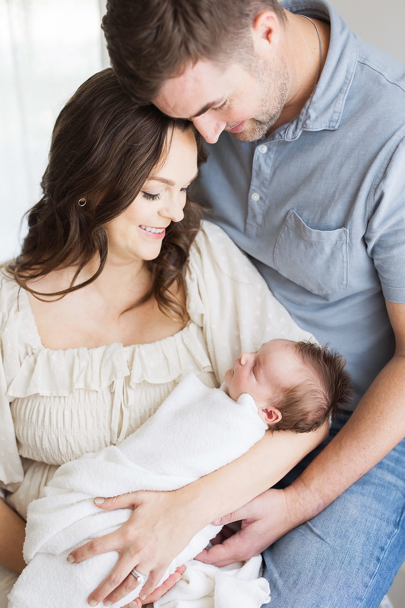 Mom and Dad holding their baby boy for newborn photos in Houston with Fresh Light Photography.
