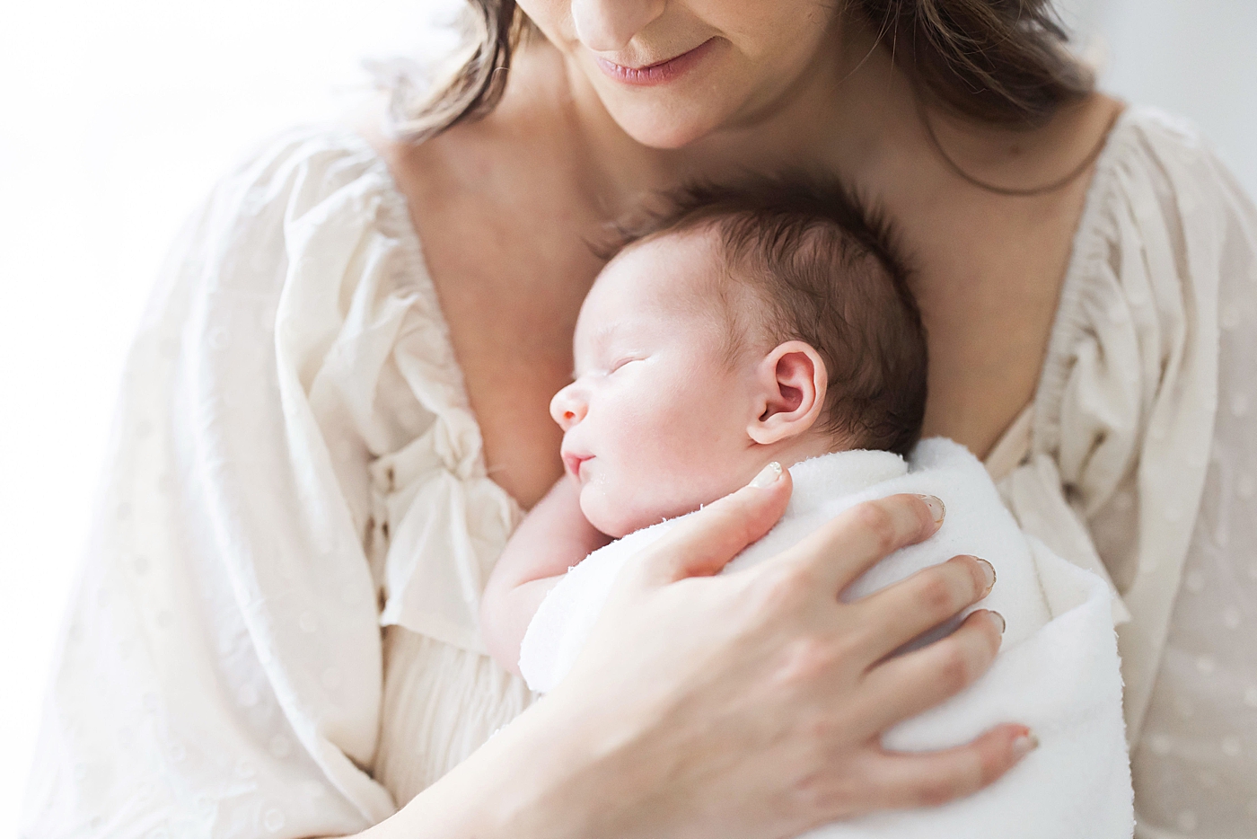 Mom holding her newborn baby boy on her chest. Photo by Fresh Light Photography.