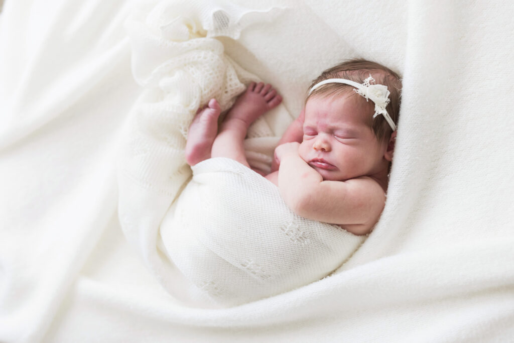 newborn wrapped in white blanket in houston
