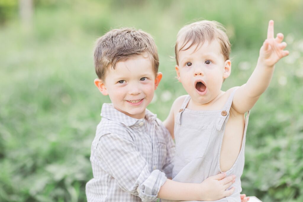 Playful interaction between brothers during an outdoor family session.