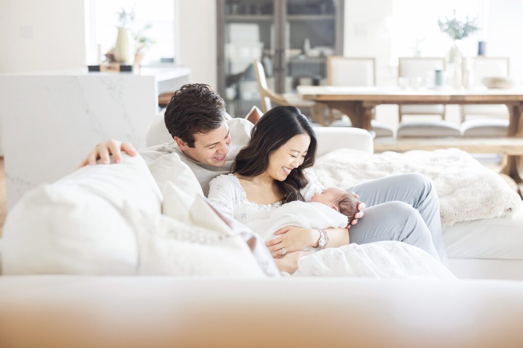 Joyful and heartwarming in-home newborn session, highlighting the connection between mom, dad, and their adorable baby.
