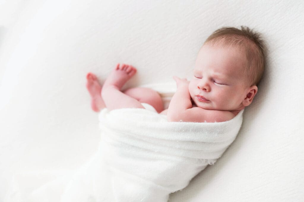 Sleeping newborn baby posed comfortably for a newborn photography session in Houston, TX