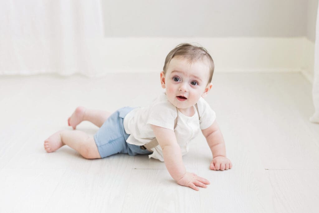 Adorable baby sitting on the floor in a Houston Heights, TX photography studio