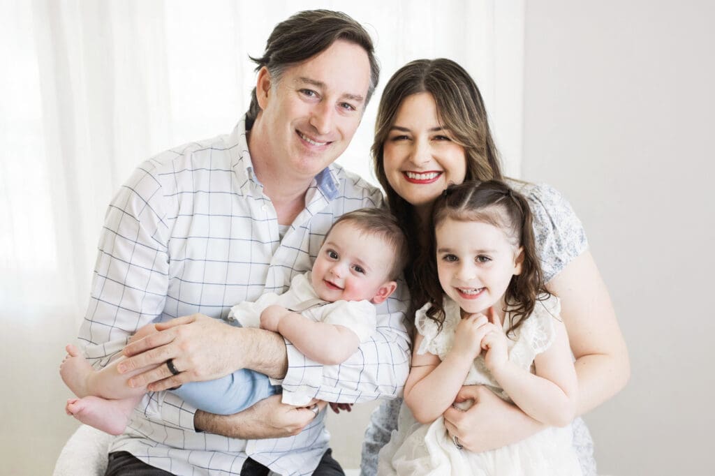Happy family posing together in a Houston Heights, TX photography studio