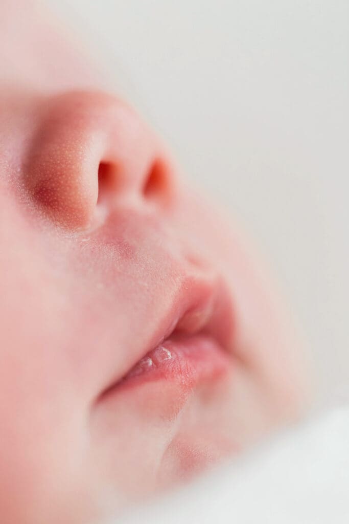 Tiny newborn baby sleeping soundly in a soft, cozy setup during a professional newborn photography session in Houston Heights, TX.