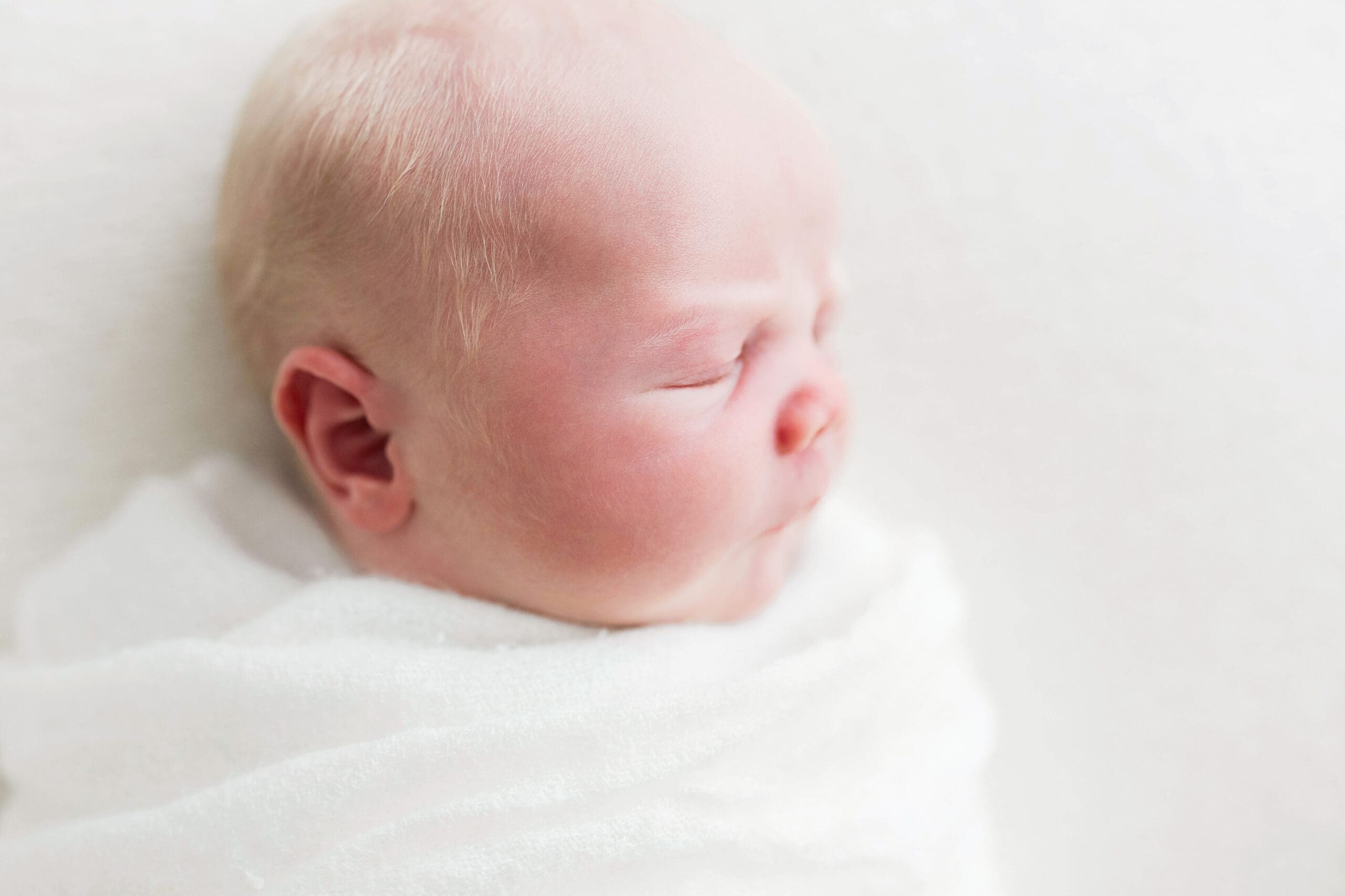 Peaceful newborn baby sleeping comfortably in a beautifully styled newborn photography setup in Houston Heights, TX, capturing the innocence of the first days of life.