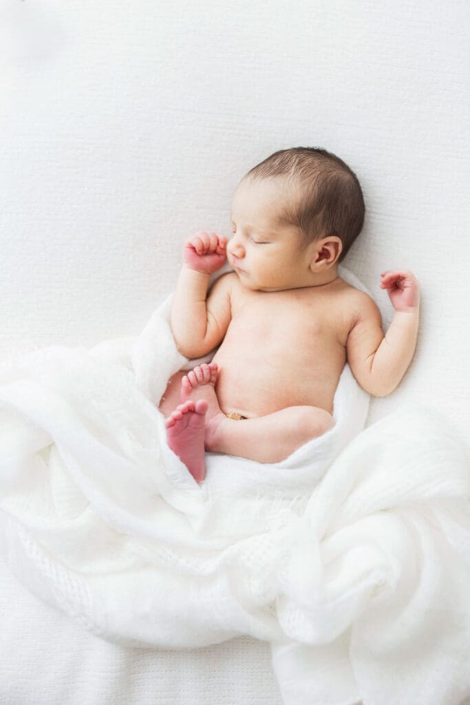 Professional newborn photographer taking photos of a sleeping newborn baby.